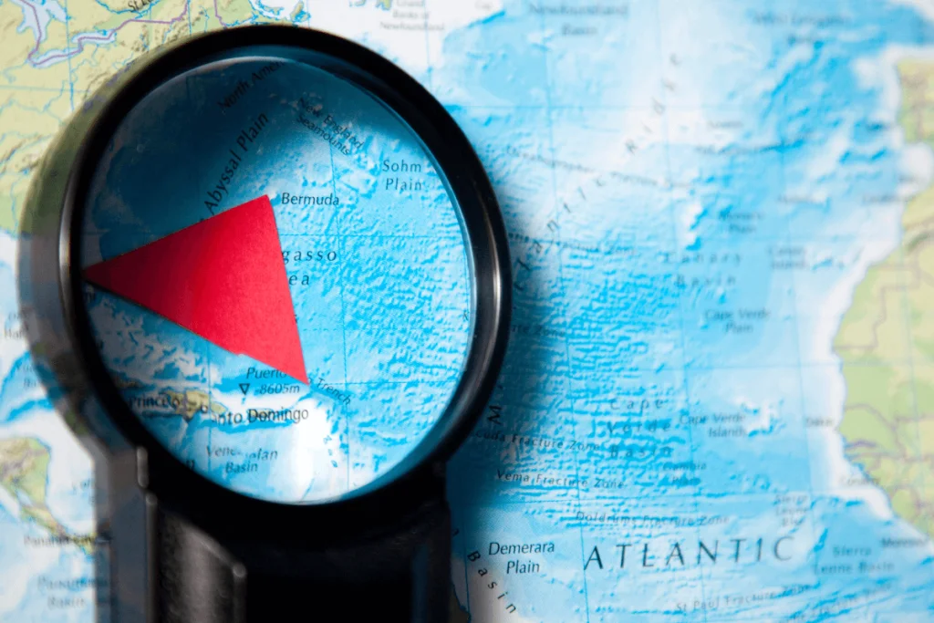 Image of a map with the area known as the Bermuda Triangle under a magnifying glass