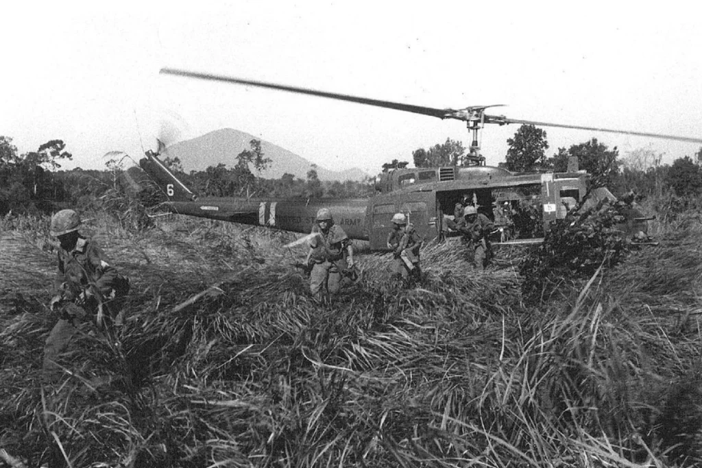Image of U.S. Army troops disembarking from a helicopter during the Vietnam War