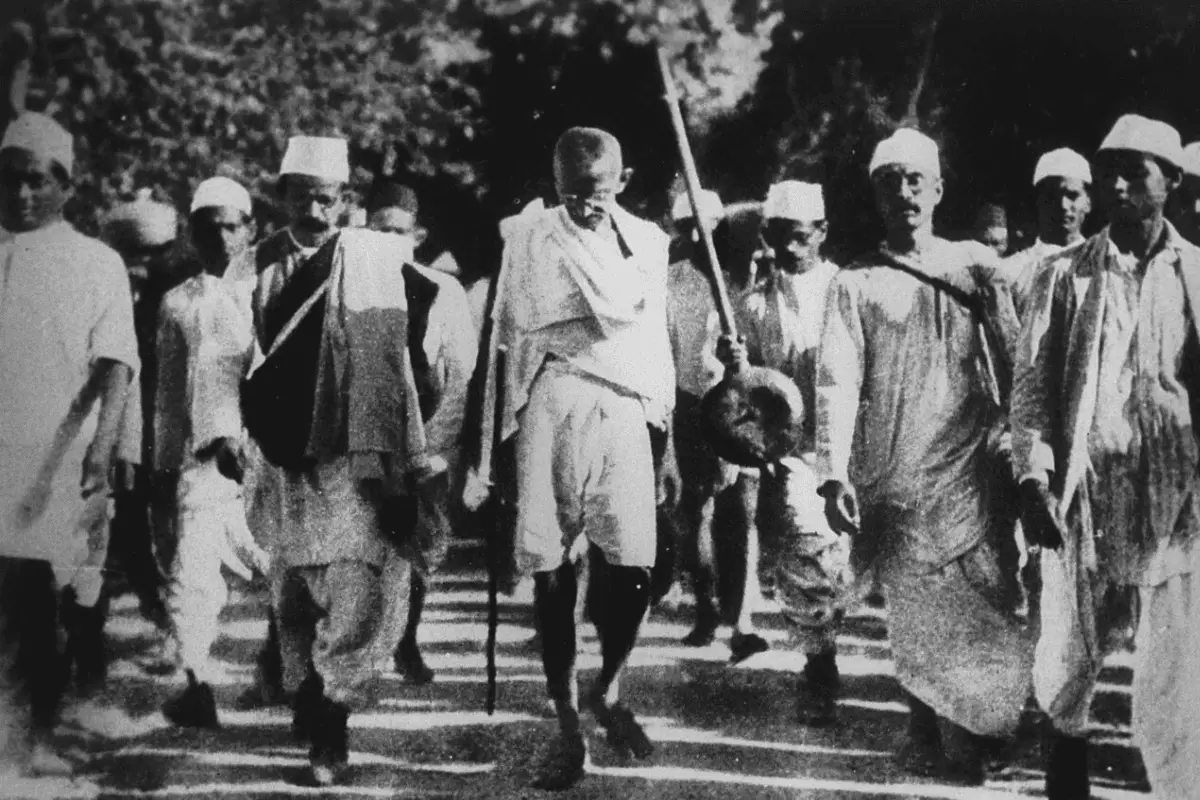 facts-about-mahatma-gandhi-main Image of Gandhi walking with supporters for a blog post covering interesting facts about Mahatma Gandhi.