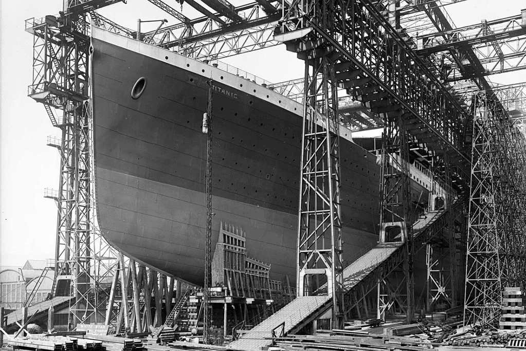 Image of a photo of the Titanic in a dry dock, captured during the ship's construction, showcasing the immense scale of this iconic vessel's creation.