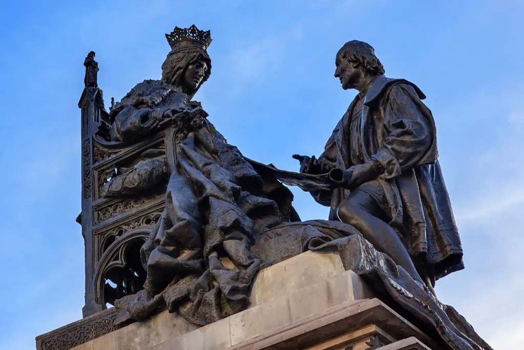 list-of-spanish-monarchs-main Image of a statue of Queen Isabella of Spain and Christopher Columbus for a blog post providing a list of Spanish Kings and Queens.